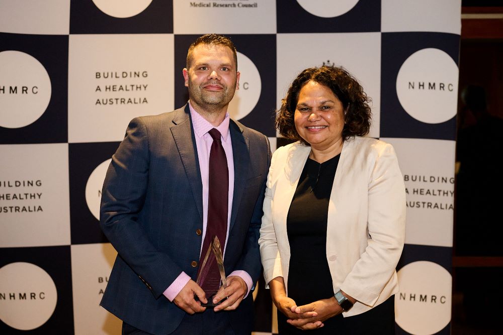 Dr Simon Graham holding award next to Professor Sandra Eades