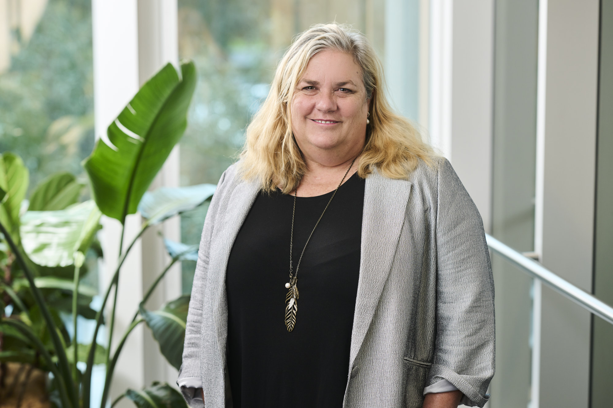 Photograph of Professor Cath Chamberlain standing in front of a plant