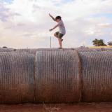 Child jumping on a hay bale