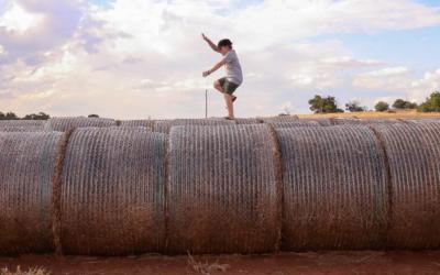 Child jumping on a hay bale